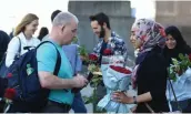  ??  ?? A Muslim girl hands over a bouquet of roses on the London on Sunday.