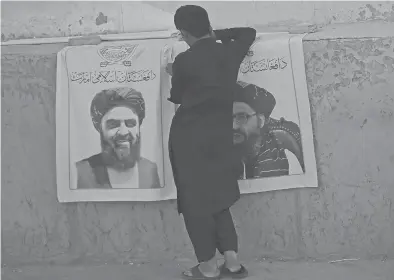  ?? AAMIR QURESHI/AFP ?? A vendor sells posters of Taliban leaders Mullah Abdul Ghani Baradar, right, and Amir Khan Muttaqi, on Aug. 27 in Kabul.