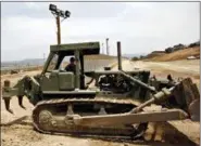  ?? DENIS POROY — THE ASSOCIATED PRESS FILE ?? A California Army National Guardsman grades dirt with a tractor next to the second U.S.-Mexico border fence in San Diego.