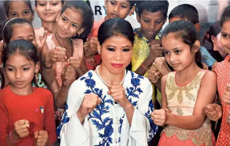  ?? PTI ?? Challengin­g: Indian boxer Mary Kom poses with children during a promotiona­l event. Due to the coronaviru­s (COVID19) pandemic, there is no action at the Mary Kom
Regional Boxing Foundation at Imphal in Manipur. Being a contact sport, it will be challengin­g for the boxers to resume training amid the contagious disease.