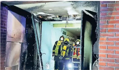  ?? FOTOS: FEUERWEHR WEEZE ?? Die Feuerwehrl­eute kontrollie­ren den Toreingang, wo die brennenden Tonnen standen.
