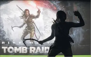  ?? Michael Nelson
European Pressphoto Agency ?? A WOMAN
emulates hero Lara Croft in front of a poster for the hotly anticipate­d “Rise of the Tomb Raider.”