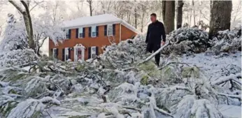  ?? MIKE STEWART/THE ASSOCIATED PRESS ?? Tom Virgili surveys heavy tree damage following a nasty snowfall hit Kennesaw, Ga., on Saturday.