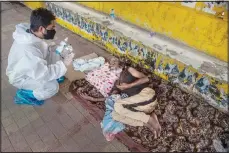  ?? (AP) ?? A health worker persuades a homeless man to get himself inoculated against the coronaviru­s in Guwahati, India, June 13.