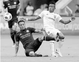  ?? JOHN RAOUX/ASSOCIATED PRESS ?? Orlando City defender Mohamed El-Munir, left, tries to knock the ball away from Real Salt Lake’s Joao Plata during the first half of Sunday’s match at Orlando City Stadium.