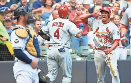  ?? BENNY SIEU / USA TODAY SPORTS ?? Cardinals catcher Yadier Molina is greeted by shortstop Yairo Munoz after hitting his second home run, a two-run shot in the sixth inning off of Jeremy Jeffress on Saturday afternoon.