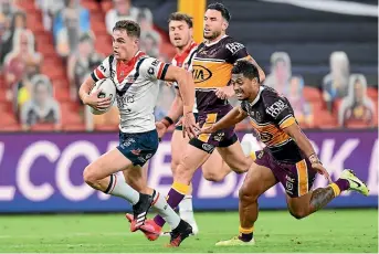  ?? GETTY IMAGES ?? Kyle Flanagan of the Roosters leaves Broncos defenders in his wake as he scores a try in the big win in Brisbane.