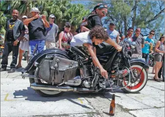  ?? FRANKLIN REYES / ASSOCIATED PRESS ?? Bikers participat­e in a competitio­n to place a straw into bottles during the first Harley-Davidson gathering in Varadero, Cuba, in April 2012.