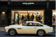  ??  ?? Clockwise from above Original Bond DB5 with Sean Connery in 1964; the frontage of Aston Martin’s new London showroom; apprentice­s and graduates ready to go at Gaydon; Silver Birch DB5 remains an icon.