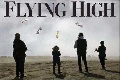  ?? P.V. NGUYEN VIA AP ?? From right, Scott Weider, Cardin Nguyen and Linda Marsland are shown flying kites in the fog at Long Beach, Wash.