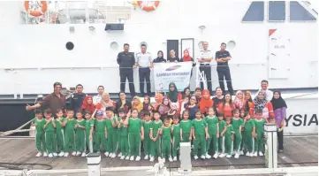  ??  ?? Teachers, pupils and their parents posing with MMEA officers in front of one of the vessels.