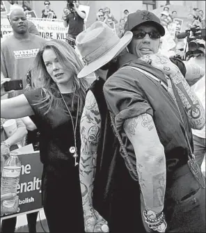  ?? Arkansas Democrat-Gazette/STEPHEN B. THORNTON ?? Former Arkansas death-row inmate Damien Echols (right) hugs actor Johnny Depp during the rally against the death penalty Friday at the state Capitol. At left is Echols’ wife, Lorri Davis.