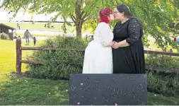  ?? ERIKA SCHULTZ THE SEATTLE TIMES ?? Sara Morosan, left, and her wife, Allyssa Howard, kiss after their wedding at Peace Arch State Park on the border between the United States and Canada.