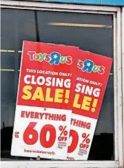  ??  ?? Signs in an Oklahoma City Toys R Us advertise discounts for its going-out-of-business sale.