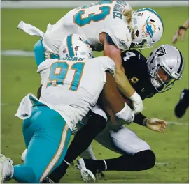  ?? STEVE MARCUS – THE ASSOCIATED PRESS ?? Miami Dolphins defensive end Emmanuel Ogbah (91) and linebacker Andrew Van Ginkel (43) tackle Raiders quarterbac­k Derek Carr during the first quarter Saturday night.