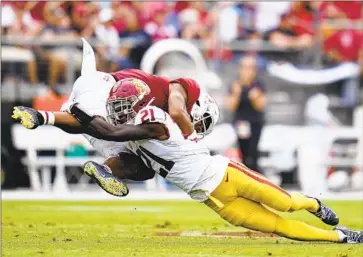  ?? STANFORD RECEIVER Godofredo A. Vásquez Associated Press ?? Elijah Higgins is upended by USC defensive back Latrell McCutchin in first half.