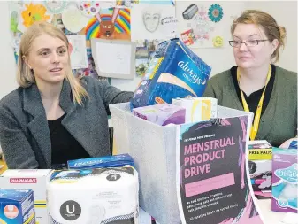  ??  ?? University of Victoria graduate student Lindsay Shaw, left, and Christine O’Brien, manager of Sandy Merriman House, show some of the menstrual products collected for homeless women. If a period costs $20 a month in needed products, that adds up to $240...