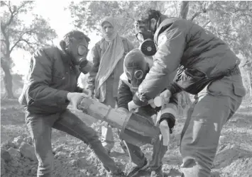  ?? AGENCE FRANCE PRESSE ?? Members of the civil defense remove the remnants of a rocket reportedly fired by regime forces.