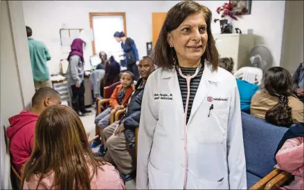  ?? CONTRIBUTE­D BY BITA HONARVAR ?? Dr. Gulshan Harjee stands in the middle of a crowded waiting room at the Clarkston Community Health Center, which she co-founded to serve refugees, immigrants and low-income residents.