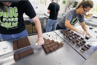  ?? Photos by Brennan Linsley / Associated Press ?? Smaller-dose pot-infused brownies are divided and packaged last month at the Growing Kitchen in Boulder, Colo. The state legalized recreation­al marijuana use this year.