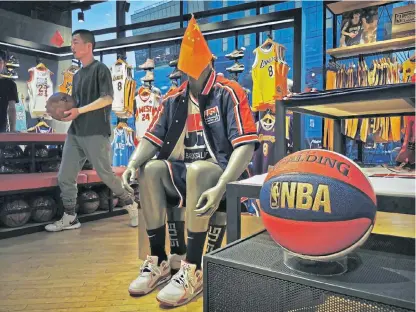  ?? Images /Getty ?? Patriots: A Chinese flag draped on a mannequin wearing the USA basketball uniform in the NBA flagship retail store on Wednesday in Beijing, China.