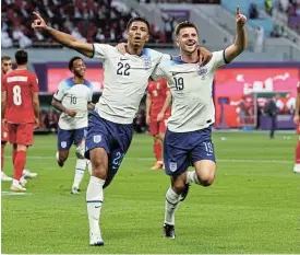  ?? /Reuters ?? Glory boys: Jude Bellingham, left, celebrates scoring England’s first goal with teammate Mason Mount in their opening World Cup match against Iran on Monday.