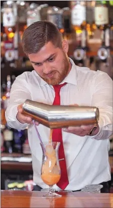  ??  ?? Bar Manager Thomas Sztacho prepares a cocktail.