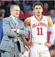  ??  ?? Oklahoma coach Lon Kruger talks with Trae Young during Tuesday’s game between the University of Oklahoma Sooners and the Kansas Jayhawks in Norman. The Sooners won, 85-80.