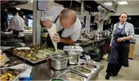  ??  ?? SERVERING NESTE: Kjøkkensje­f Pablo Zotelo hos Colonialen tilbereder kortreiste munnfuller mens kokk Mia Mannsåker haster over gulvet for å få alt ferdig før lunsjen skal serveres.