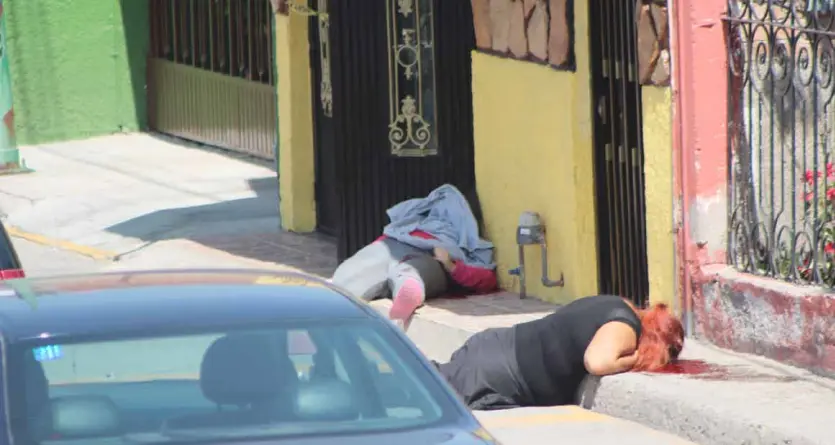  ?? Especial ?? El cuerpo de “La Chuki” quedó tirado en la puerta de un domicilio, a unos cuantos metros y al filo de la banqueta estaba el cadáver de Lorena.