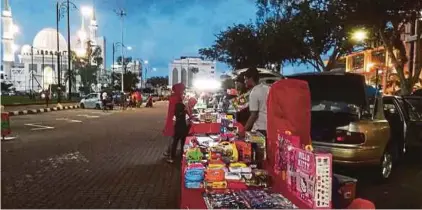  ?? PIC BY MUHAMMAD ASYRAF SAWAL ?? Car boot sale traders plying their trade at the parking lots in Taman Kerang, Kuantan, on Thursday.