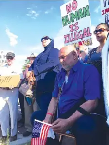  ?? ASSOCIATED PRESS FILE PHOTOS ?? Kadhim Al-bumohammed, kneeling right, a 64-year-old Iraqi refugee in the U.S., listens to speakers at an Albuquerqu­e, N.M., rally in his honor.