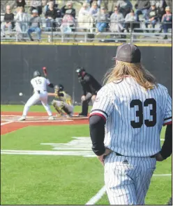  ?? Daniel Bereznicki/McDonald County Press ?? Head coach Heath Alumbaugh looks on as Destyn Dowd (No. 15) swings at bat.