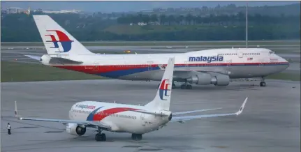  ?? PICTURE: REUTERS ?? DOWNWARD: Malaysia Airlines aircrafts taxi at Kuala Lumpur Internatio­nal Airport. Shares of the carrier hit a record low on Monday after huge reported quarterly losses due to the disappeara­nce of flight MH370.