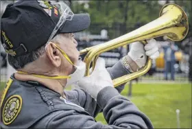  ??  ?? A bugler plays taps Monday as a motorcade of veterans stops outside the VA Medical Center for a wreath laying ceremony in Brooklyn.