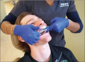  ?? STAN HUDY SHUDY@DIGITALFIR­STMEDIA.COM @STANHUDY ON TWITTER ?? Shenendeho­wa junior defenseman Christophe­r Lasher has a mold filled with compound placed against his top teeth to create a mold for this year’s hockey mouth guard courtesy of Clifton Park Othodontic­s.