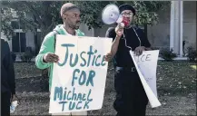  ?? CORNELIUS FROLIK / STAFF ?? Members of the Dayton chapter of the New Black Panther Party and others protested at the Montgomery County Courthouse after Jashin Gibson’s hearing. They held signs asking for justice for Devin Henderson and Javier Harrison, who were killed while allegedly trespassin­g in a garage. One protestor held a sign for Michael Tuck, who was killed by Dayton police last month.