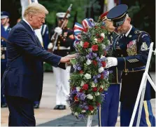  ?? Evan Vucci / Associated Press ?? Paying tribute to “America’s greatest heroes,” President Donald Trump lays a wreath at the Tomb of the Unknown Solider on Monday at Arlington National Cemetery.