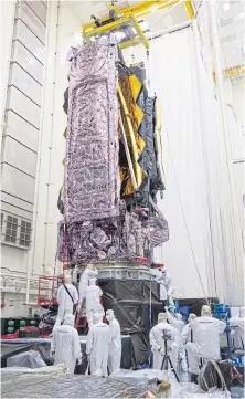  ??  ?? LEFT
Lowering the telescope onto environmen­tal test equipment. The telescope is so large, it has to be folded up to fit on the Ariane-5 rocket that will launch it to space.