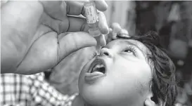  ?? K.M. Chaudary/Associated Press ?? A health worker administer­s a polio vaccine on Aug. 22 to a child in Lahore, Pakistan, one of two countries where the disease is endemic today.