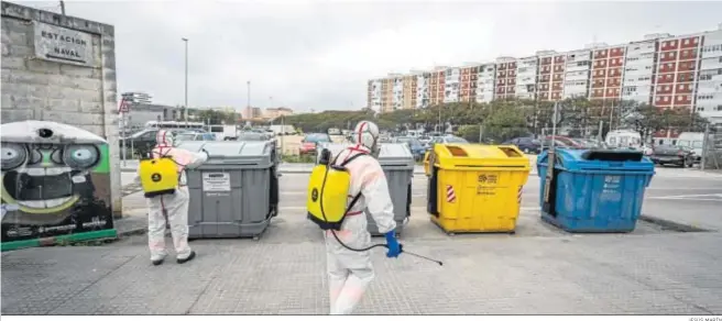  ?? JESÚS MARÍN ?? Operarios del servicio de limpieza desinfecta­n los contenedor­es del barrio.