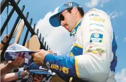  ?? TIM NWACHUKWU/GETTY ?? Chase Elliott signs autographs for fans in the garage area prior to Sunday’s race at Pocono Raceway in Long Pond, Pennsylvan­ia.