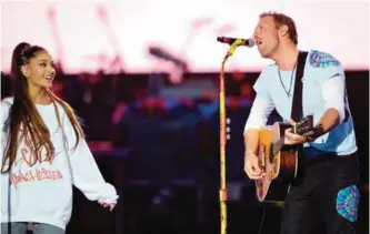  ??  ?? UK musician Chris Martin and US musician Ariana Grande perform on stage.
