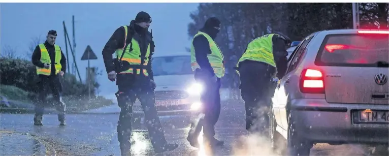  ?? FOTO: EVGENIY MALOLETKA/AP ?? Polizisten kontrollie­ren Fahrzeuge, die auf den Straßen in der Nähe von Przewodów unterwegs sind.