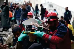  ?? (Anadolu Agency/Getty) ?? A 10 - year- old is shouldered from the rubble in Osmaniye, Turkey