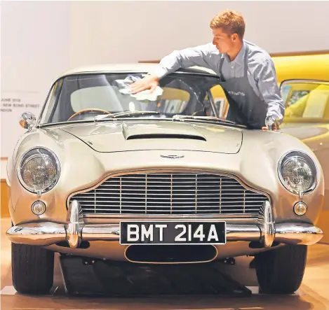  ??  ?? A 1965 Aston Martin DB5 driven by Pierce Brosnan as James Bond in the 1995 film GoldenEye, is prepared at Bonhams in central London, before going up for auction on July 13 at the Bonhams Goodwood Festival of Speed Sale for an estimated £1.2 to £1.6...