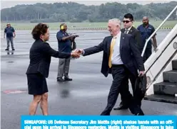  ?? —AFP ?? SINGAPORE: US Defense Secretary Jim Mattis (right) shakes hands with an official upon his arrival in Singapore yesterday. Mattis is visiting Singapore to take part in a regional security summit.