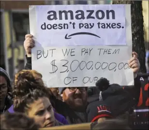  ?? AP PHOTO/BEBETO MATTHEWS ?? In this Nov. 14 file photo, protesters hold up anti-Amazon signs during a coalition rally and press conference of elected officials, community organizati­ons and unions opposing Amazon headquarte­rs getting subsidies to locate in Long Island City, in New York.