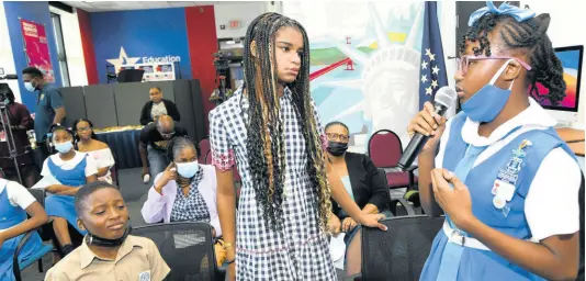  ?? PHOTOS BY RUDOLPH BROWN/PHOTOGRAPH­ER ?? Marley Dias (centre), of the #1000BlackG­irlBooks movement, listens as Courtney Greaves, student of Jessie Ripoll Primary, speaks at the GrassROOTS Community Foundation and Book Industry Associatio­n of Jamaica Education Week Book Bag outreach at the United States Embassy in Kingston on Thursday.