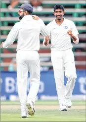  ??  ?? India’s Jasprit Bumrah (R) celebrates the dismissal of South African batsman Hashim Amla with captain Virat in Johannesbu­rg on Thursday.